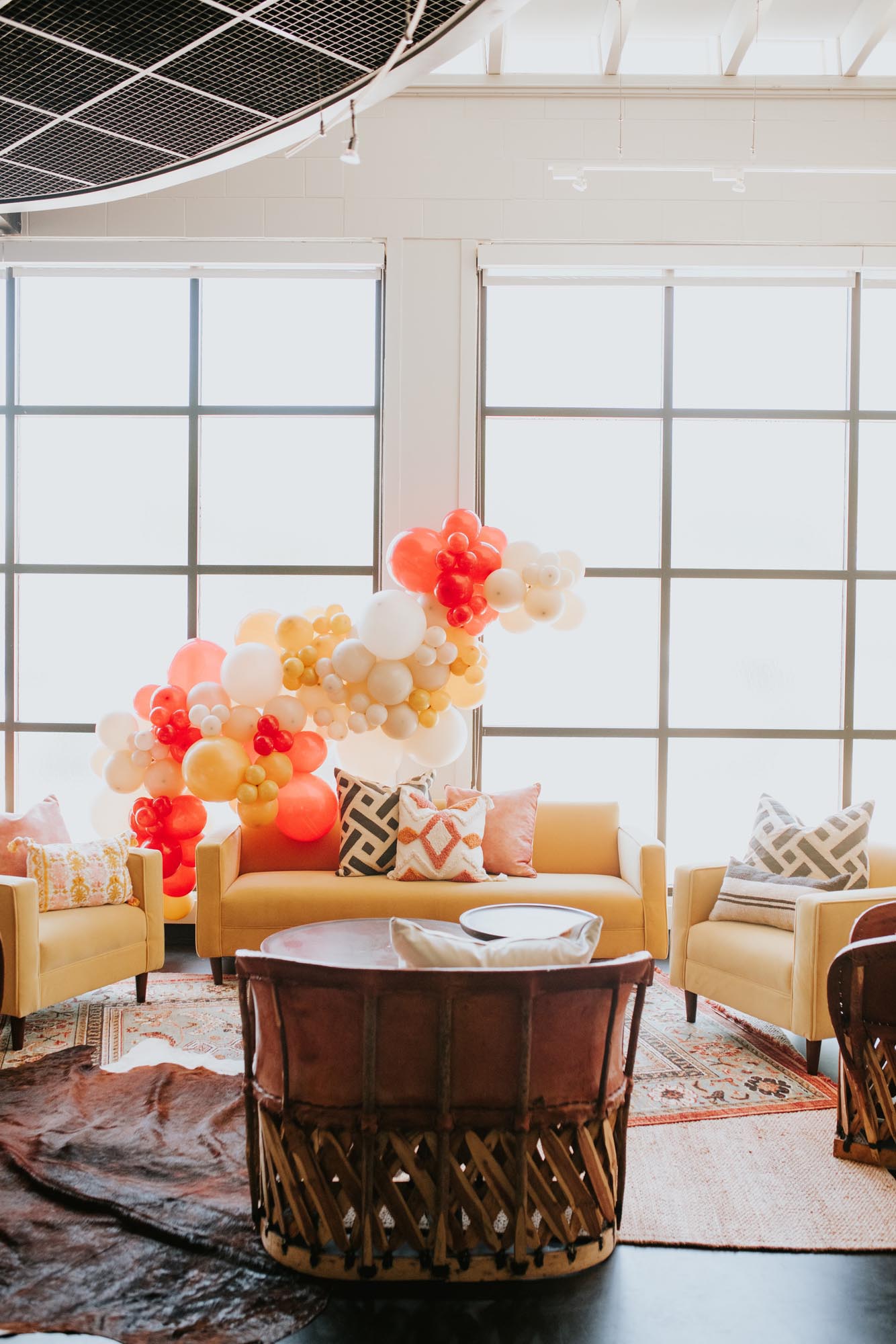 birthday party lounge seating with colorful balloon installation 